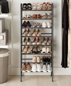 an organized closet with shoes and baskets on the floor in front of a white wall