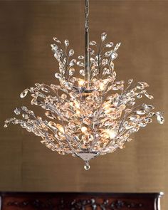 a crystal chandelier hanging from the ceiling in a room with wood flooring