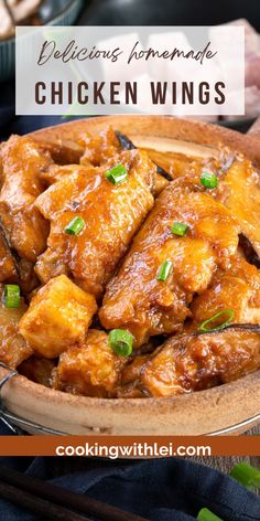 chicken wings in a brown bowl with chopsticks and green onions on the side