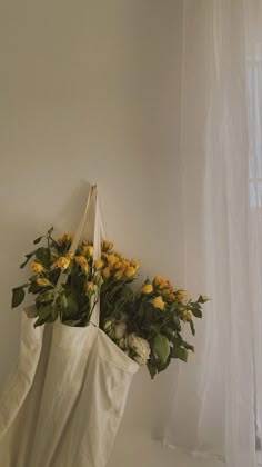 a white bag filled with yellow flowers sitting on top of a table