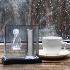 a cup and saucer sitting on a table next to a window with rain coming through it