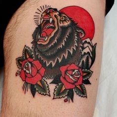 a man with a bear tattoo on his thigh and roses around the leg, showing it's teeth