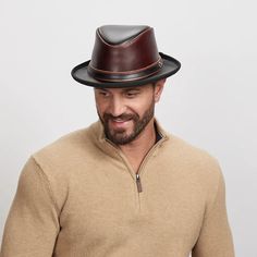 A smiling man wearing a wine colored fedora Fitted Black Leather Top Hat, Black Leather Brimmed Top Hat, Fitted Leather Top Hat With Short Brim, Brown Leather Top Hat With Curved Brim, Black Leather Top Hat With Flat Brim, Elegant Leather Fedora For Fall, Brown Leather Wide Brim Top Hat, Fitted Leather Top Hat With Flat Brim, Elegant Brown Leather Hat Bands