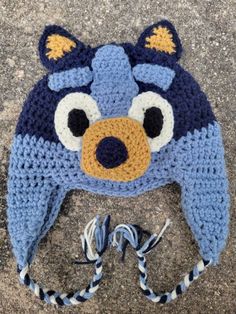 a crocheted hat with a blue and white bird on it's face