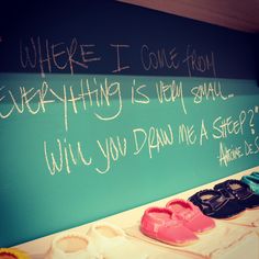 there is a chalkboard with writing on it next to some shoes and slippers