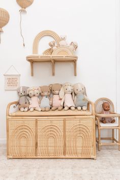 a group of stuffed animals sitting on top of a wooden bench next to a wall