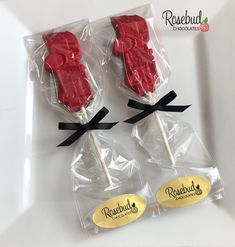 two lollipops wrapped in cellophane and tied with black ribbon