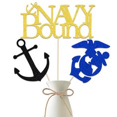 navy and marine themed cake toppers in a white vase with blue and gold decorations