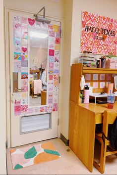 a room with a desk, chair and door that has many stickers on it