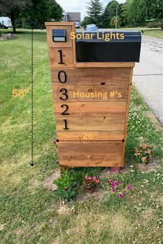 a wooden box sitting on the side of a road next to a street sign that says solar lights housing's