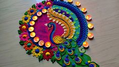 a colorful peacock made out of candles on a table