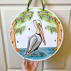 a hand holding up a plate with a pelican on it