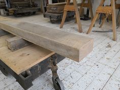 a wooden bench sitting on top of a hard wood floor next to other workbench