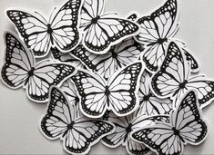 some white and black butterflies on a white surface