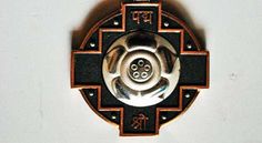 a black and silver clock with red trim on it's face hanging from a chain