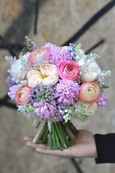 a person holding a bouquet of flowers in their hand