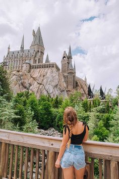 a woman standing on a balcony looking at hogwarts castle