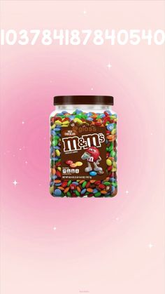 a jar filled with lots of candy on top of a pink background and the words m & m written above it