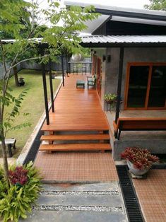 a small house with wooden steps leading up to the front door and covered porch area