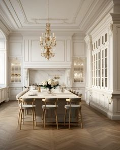 an elegant kitchen with white cabinets and marble counter tops, chandelier above the island