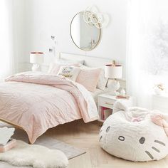 a bedroom decorated in pink and white with a hello kitty comforter on the bed