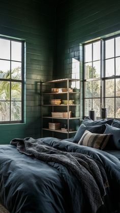 a bedroom with green walls and large windows