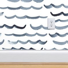 an electrical outlet in front of a wall with watercolor waves painted on it