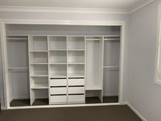 an empty white closet with shelves and drawers