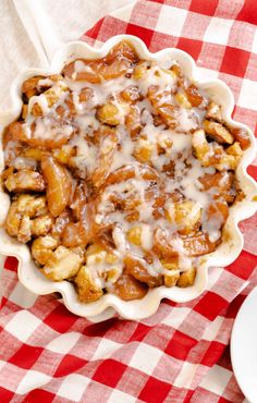 an apple cinnamon roll bake in a pie pan on a red and white checkered tablecloth