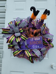 a purple and black halloween wreath with it's the shoe fits sign