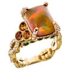 4.31 Ethiopian Opal Diamond Garnet Tourmaline Yellow and Rose Gold Cocktail Ring, In Stock. This cocktail ring features a 4.31-carat opal center stone cut by award-winning cutter, Darryl Alexander. Surrounding the Ethiopian opal are 0.88 carat total weight diamonds. There are also a 1.43-carat total weight of spessartite garnets and a 0.69-carat total weight of green tourmaline. These gemstones are set in 18 karat yellow gold and 18 karat rose gold. This cocktail ring also features Brenda Smith's signature square-round shank, with filigree and diamonds on the shank. The ring is size 6.75. This ring is a one-of-one jewelry design by the award-winning art jewelry designer Brenda Smith. Her work has been on the Red Carpet and in the Smithsonian Museum and won many awards. This ring is very ch Rose Gold Cocktail, Smithsonian Museum, Spessartite Garnet, Gold Cocktail Ring, Gold Cocktail, Creating Jewelry, Jewelry Designer, Jewelry Companies, Stone Cuts