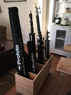 a wooden box filled with baseball bats on top of a hard wood floor next to a window