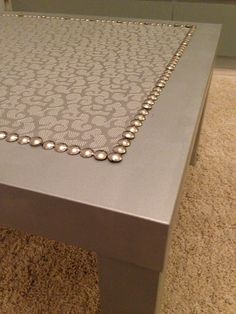 a close up of a table with a beaded cloth on the top and bottom