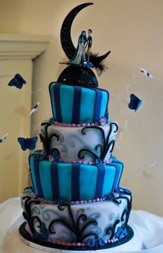 a three tiered cake with blue and black icing