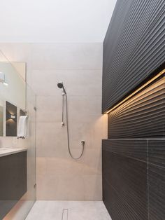 a bathroom with a shower, sink and mirror on the wall next to each other