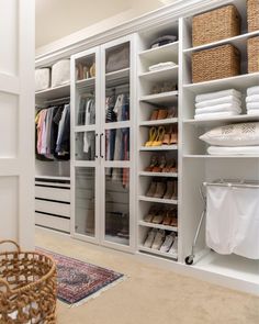 an organized closet with white shelving and wicker baskets on the floor, including shoes