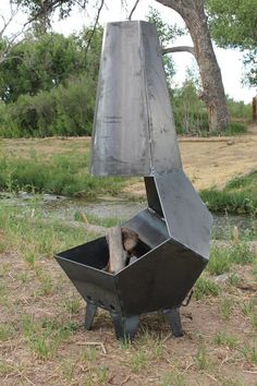 a metal sculpture sitting on top of a grass covered field