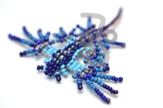 blue and black beads are arranged on a white surface