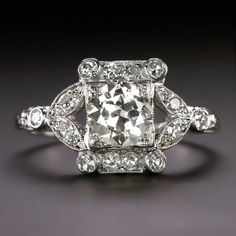 an old - fashioned diamond engagement ring is shown in this close up photo, with the center stone surrounded by smaller diamonds