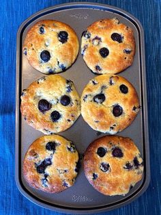 six blueberry muffins in a baking pan