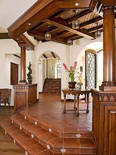 a living room filled with lots of furniture and wooden steps leading up to the second floor