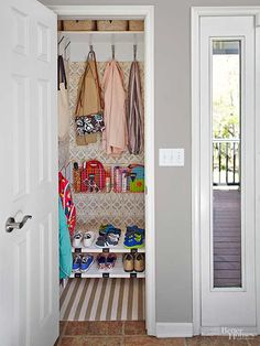 an open closet with shoes and handbags hanging on the wall next to two doors