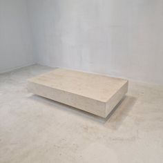 an empty room with a concrete table in the middle and no one around it on the floor