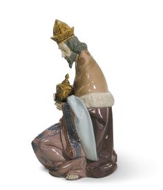 a figurine of a person sitting on the ground with a bird in their hand