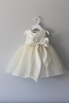 a white dress with a bow on the front and bottom, is shown in an instagram