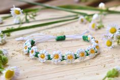 daisies and other flowers are arranged on a wooden surface with string attached to them