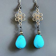 "Turquoise Teardrop Earrings - Turquoise Magnesite Teardrop Beads dangle from antiqued Brass Flower Cutouts.  The Turquoise Beads are topped with Antiqued Brass Beadcaps and Beads. Antiqued Brass  Earwires Earrings measure 2.25\" from top of earwires to bottom of beads." Blue Bohemian Teardrop Earrings For Gift, Blue Bohemian Teardrop Earrings Gift, Bohemian Blue Teardrop Earrings For Gifts, Vintage Turquoise Flower Earrings, Turquoise Earrings With Flower Charm, Turquoise Flower-shaped Earrings With Flower Charm, Turquoise Nickel Free Flower Earrings, Nickel Free Turquoise Flower Earrings, Adjustable Turquoise Teardrop Earrings