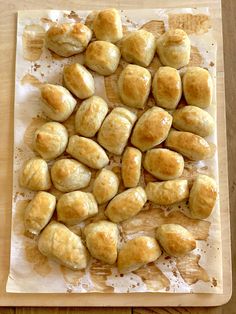 bread rolls are on a cutting board ready to be baked