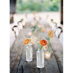 several vases filled with flowers sitting on top of a wooden table