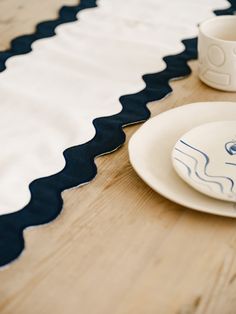 a table with plates and cups sitting on top of it next to a cup, saucer and spoon